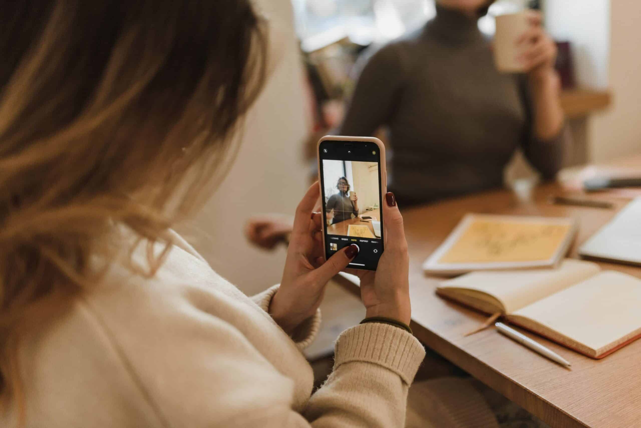 Operatore che realizza una ripresa video verticale con smartphone per contenuti social aziendali
